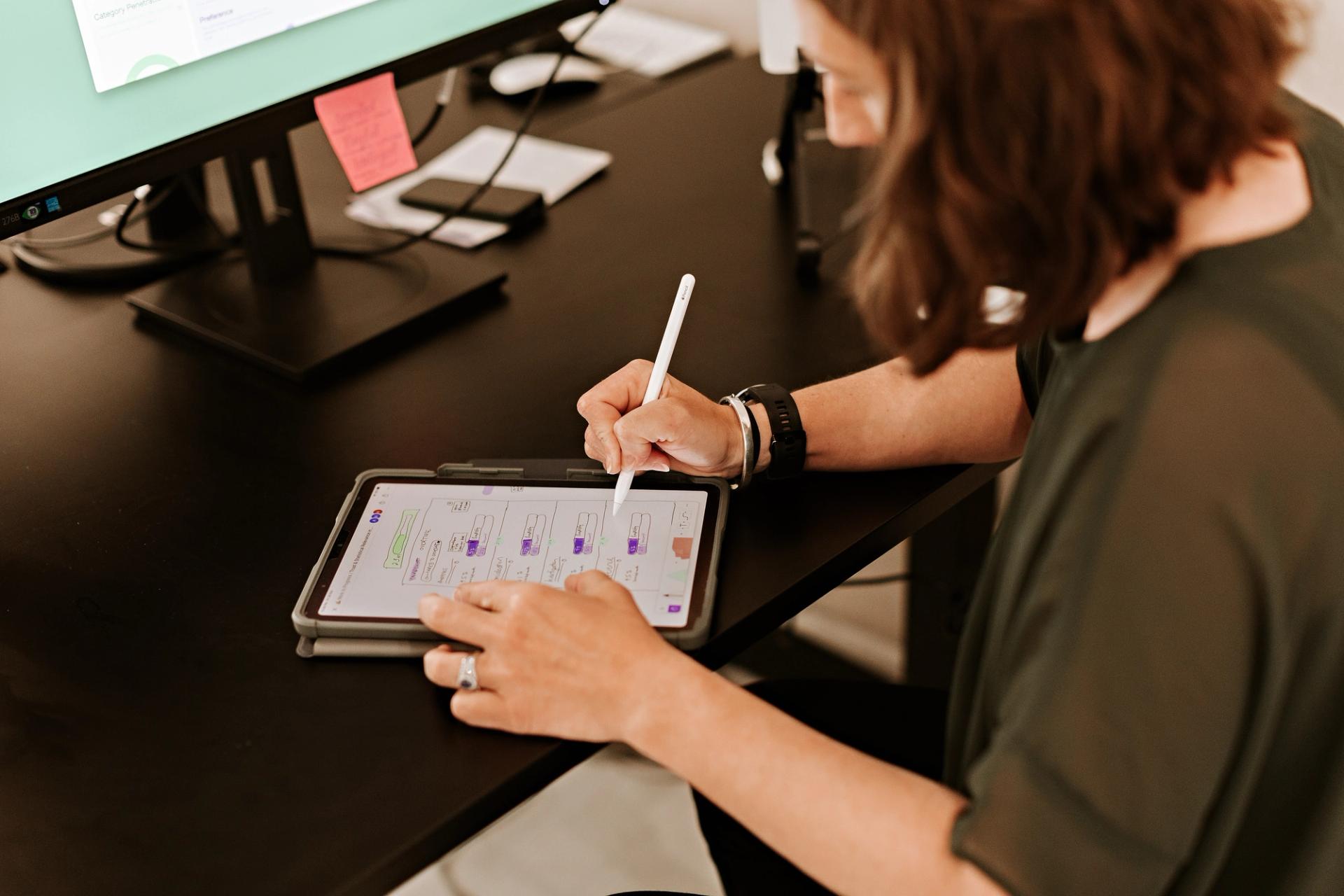 woman in office making notes on a tablet