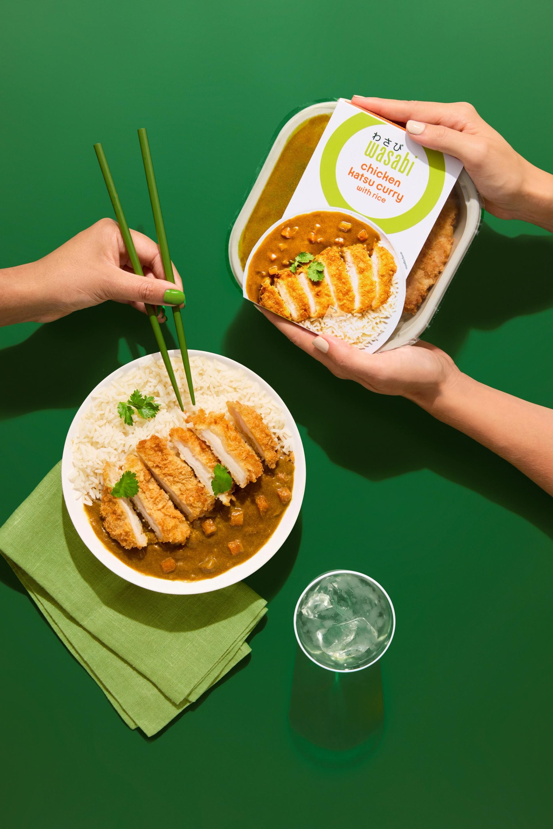 Two individuals enjoying Wasabi's chicken katsu curry with chopsticks, highlighting the brand's commitment to authentic Asian flavors and convenient ready-made meals.
