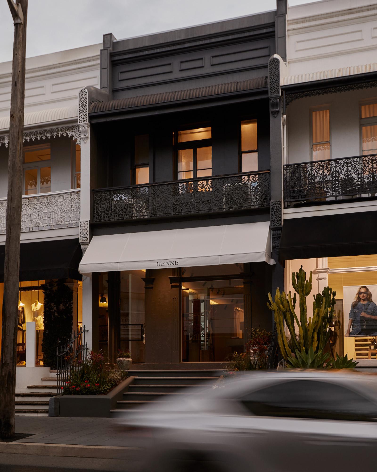The exterior of Henne's first Sydney store, a black building with a white awning displaying the brand name 'Henne'.