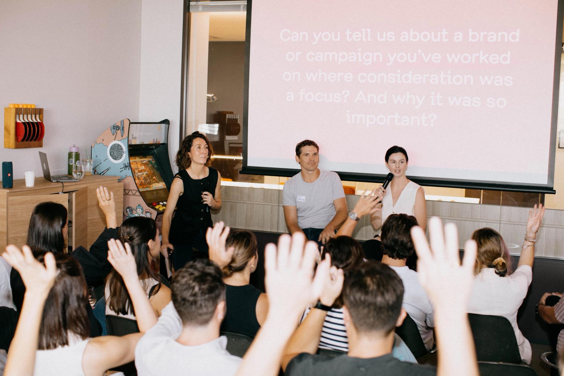 A group of people sitting in front of a projector screen at the Breakfast of Brand Champions event