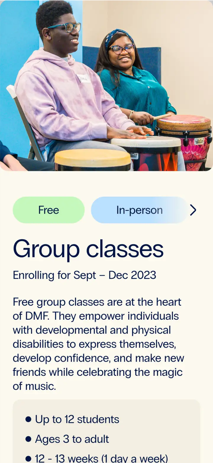 A mobile screen showing the card for group classes, with a photo of two participants smiling while playing drums
