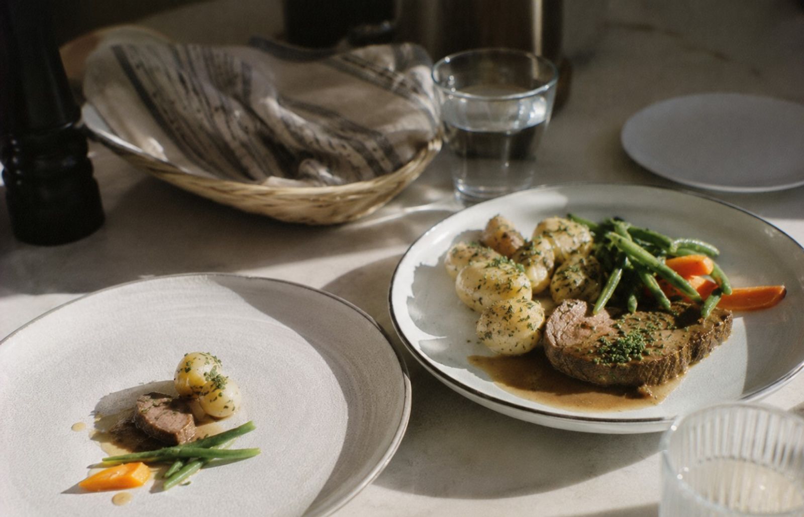 Två tallrikar med samma maträtt, en med en mycket liten portion och en med en normal portion.