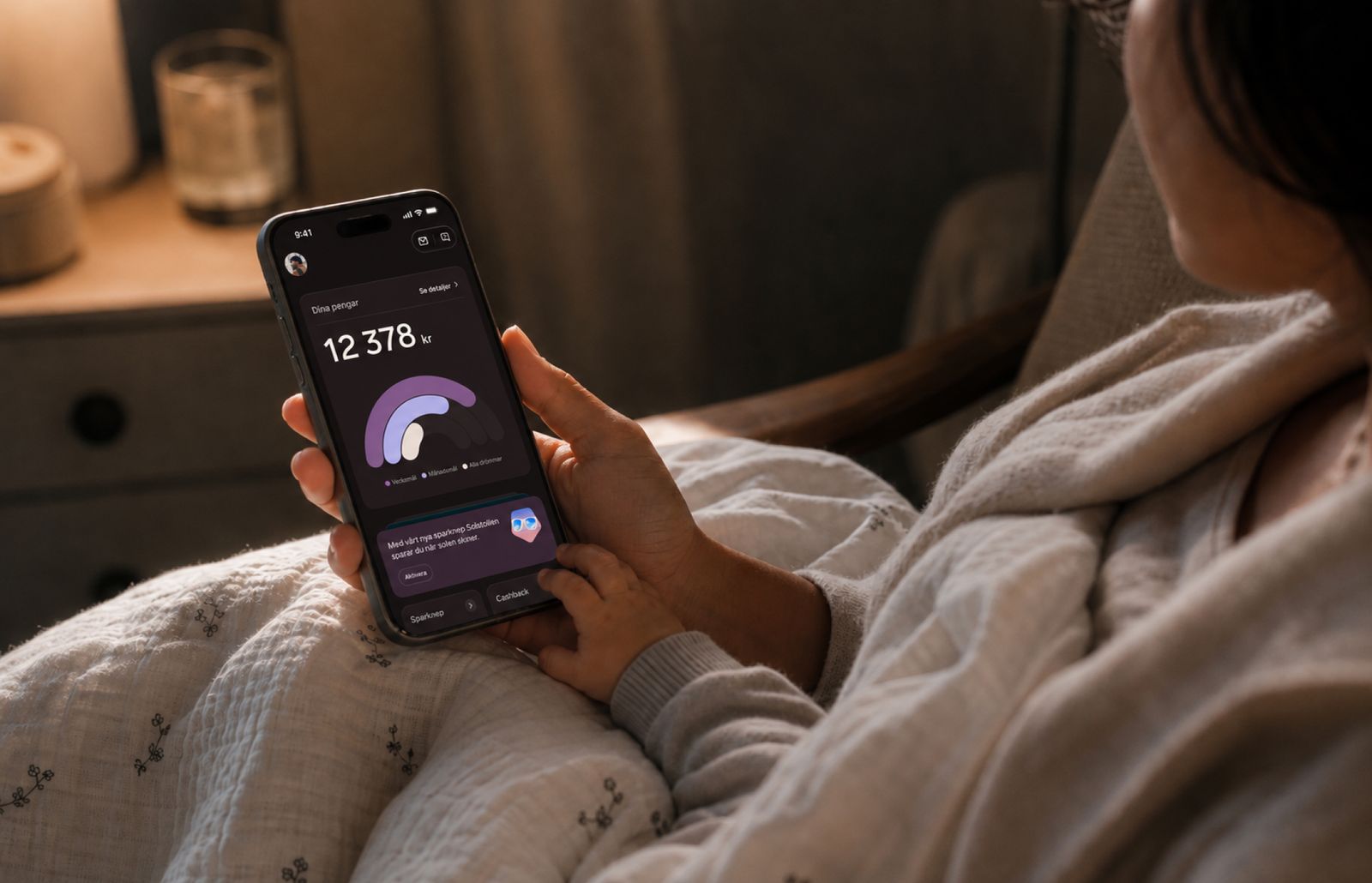 En vuxen håller en mobiltelefon medan ett litet barn rör vid skärmen, som visar en sparöversikt i Dreams.