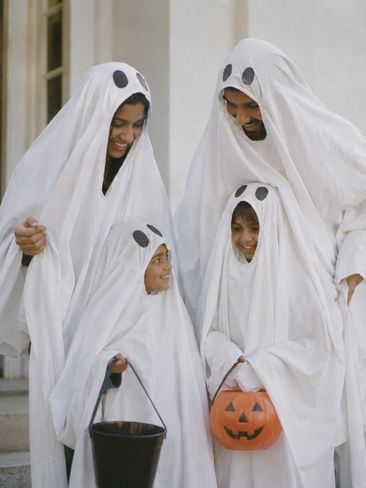 En familj som är utklädda till spöken inför halloween