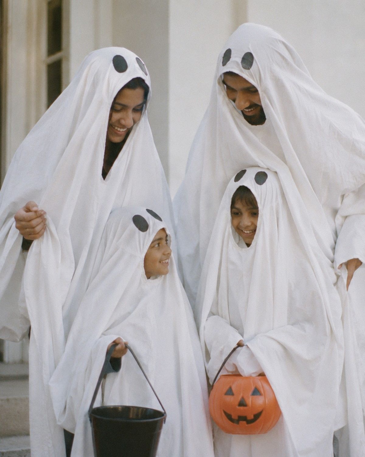 En familj som är utklädda till spöken inför halloween