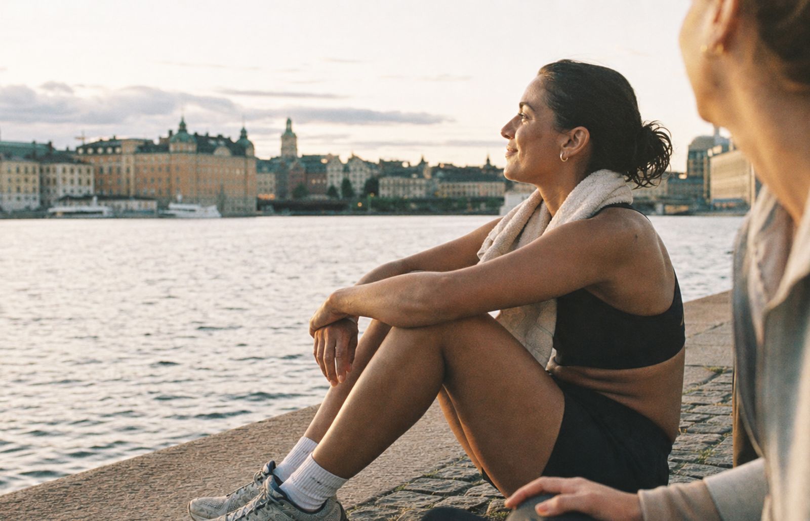 Två vänner sitter vid vattnet i Stockholm efter en löptur.