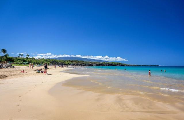 Wide white sand and turquoise water at Hāpuna Beach.
