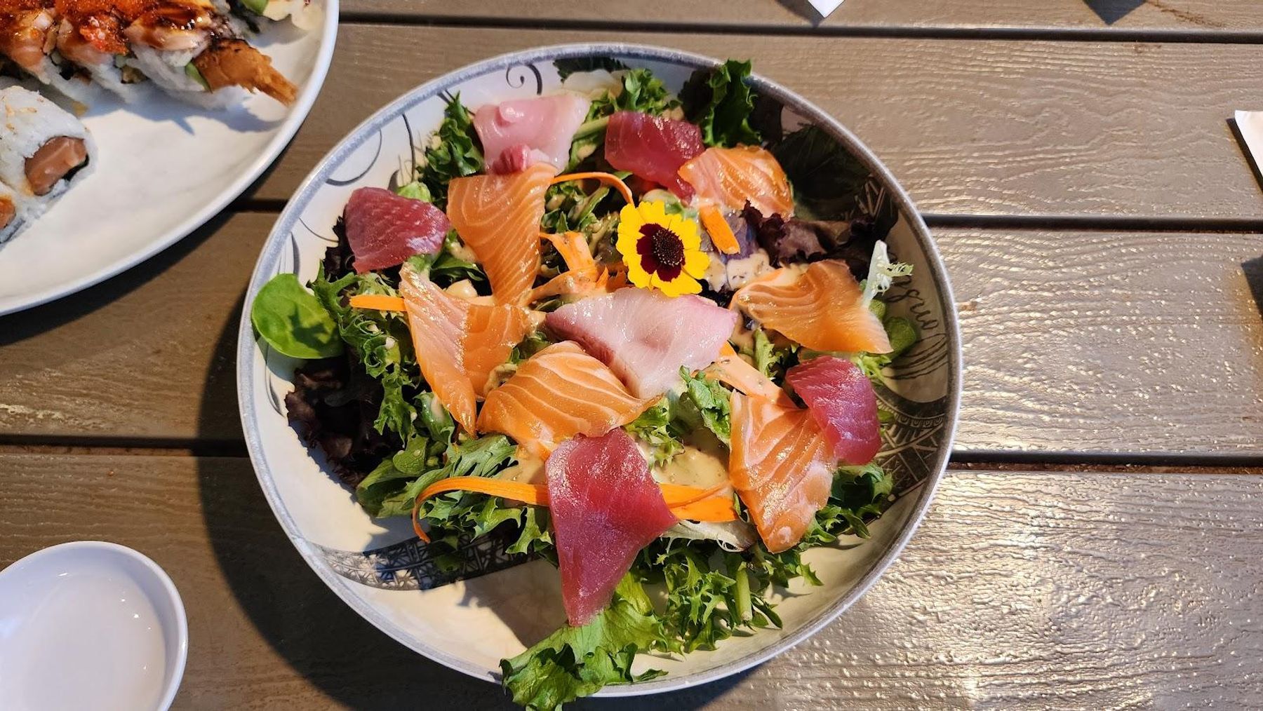 Vibrant sashimi salad bowl with fresh salmon, tuna, and edible flowers from a Kauai food truck