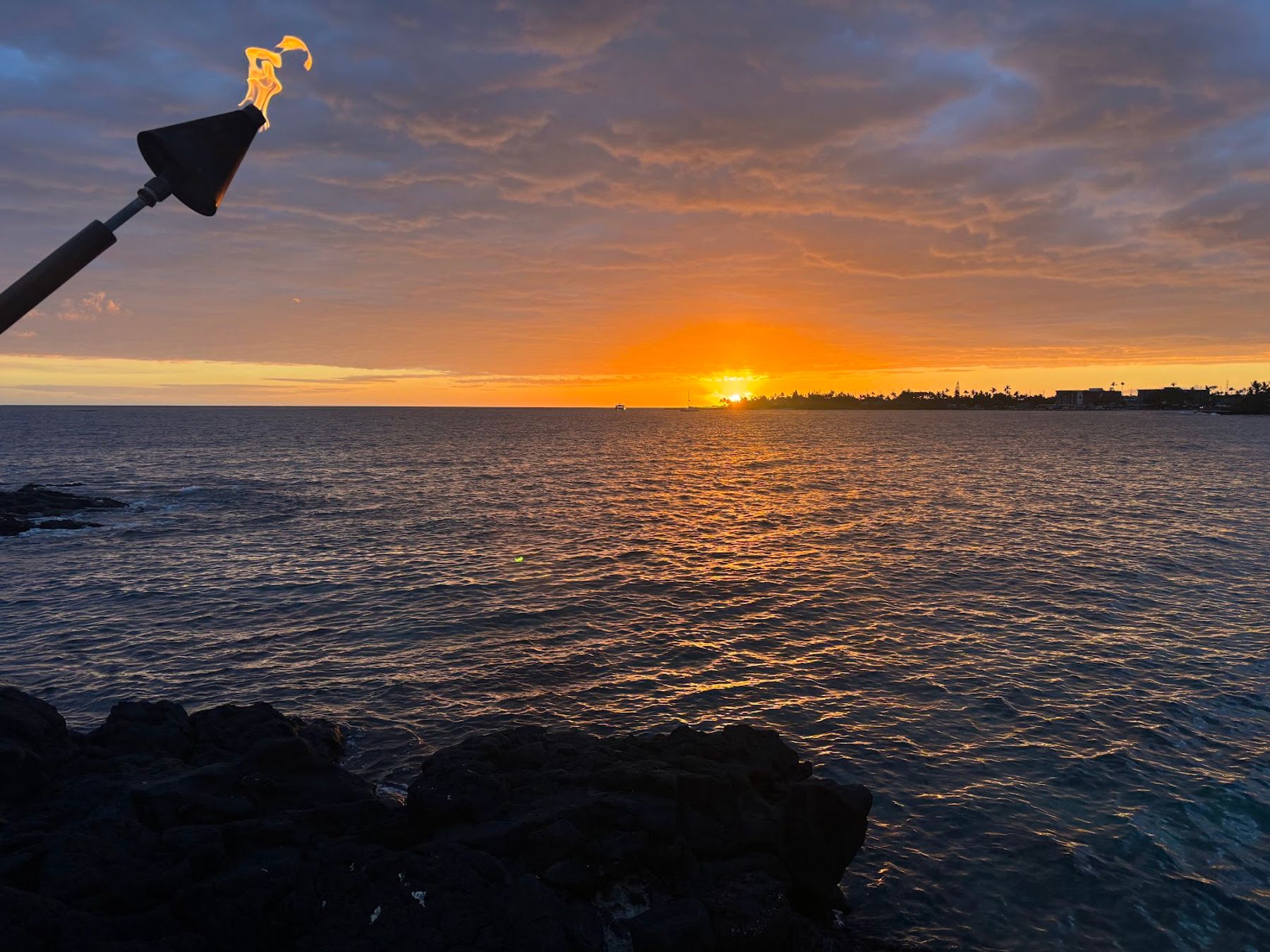 Sunset over the ocean from the shoreline beside Huggo's in Kailua-Kona.