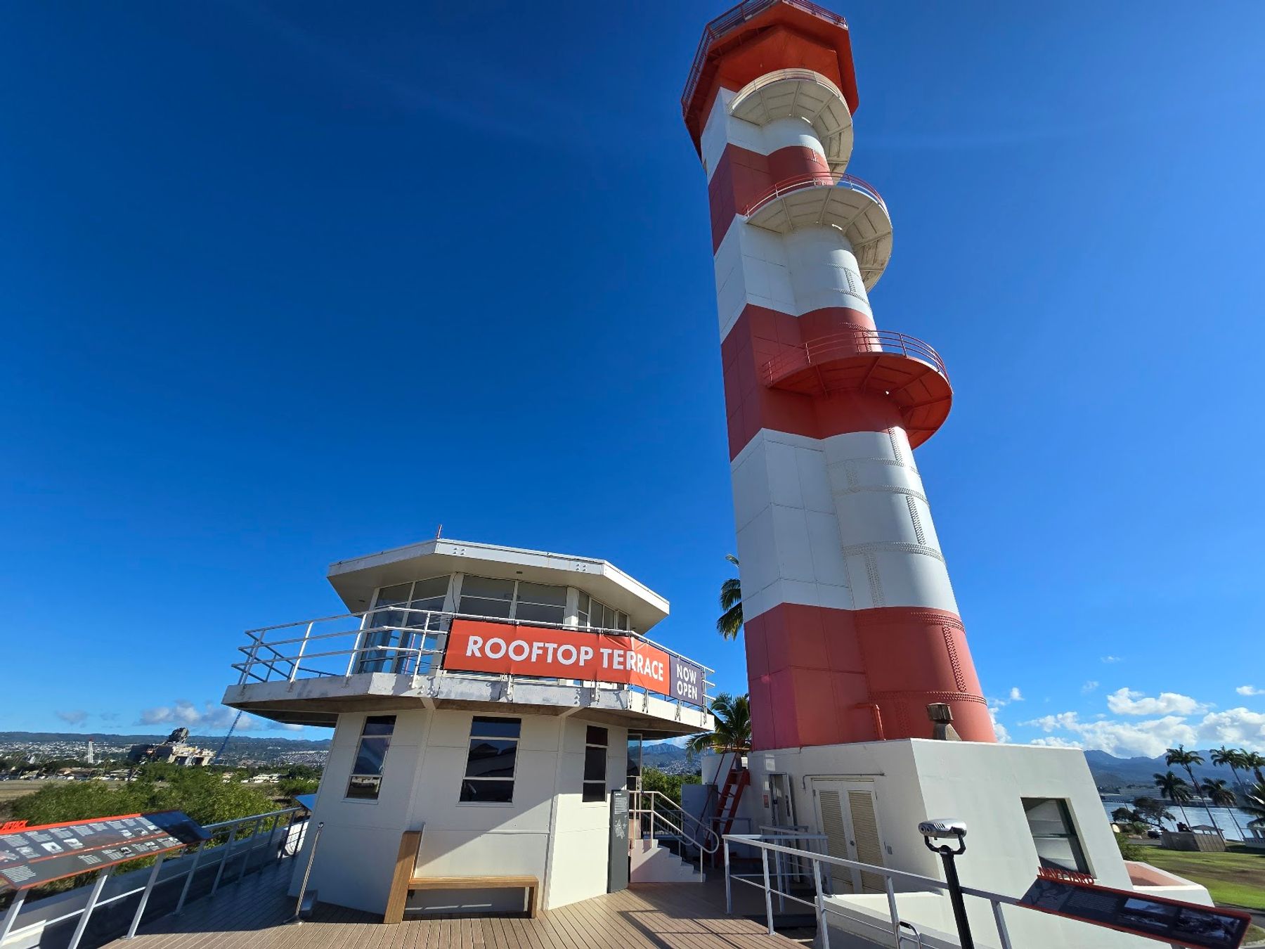 The red-and-white Ford Island Control Tower and rooftop terrace at Pearl Harbor Aviation Museum under a clear blue sky.
