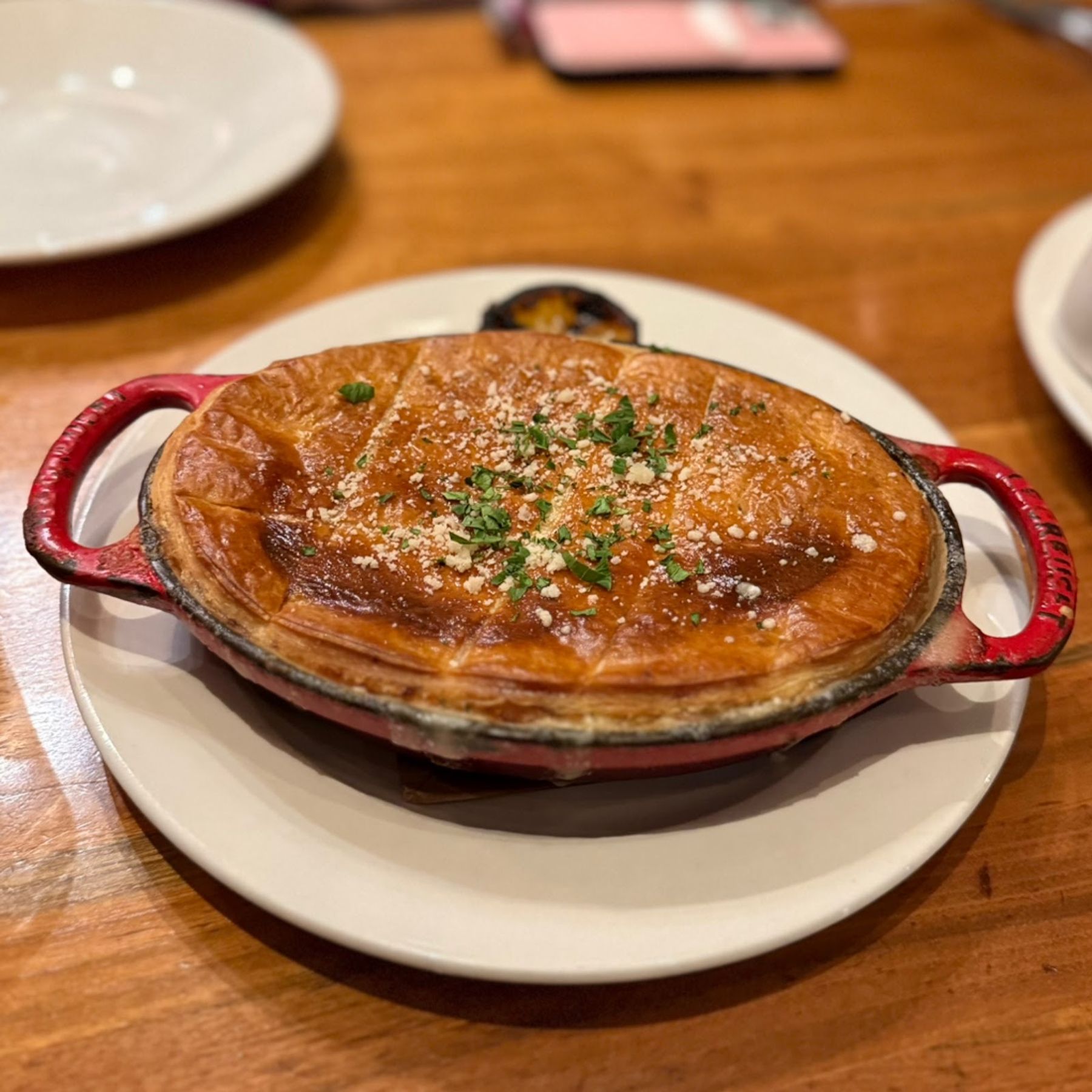 A golden baked savory pie served in a small red dish at Merriman's Honolulu.