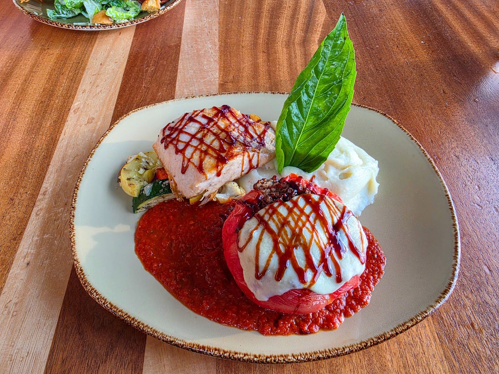 A colorful plated entree at Huggo's with red sauce and fresh basil.