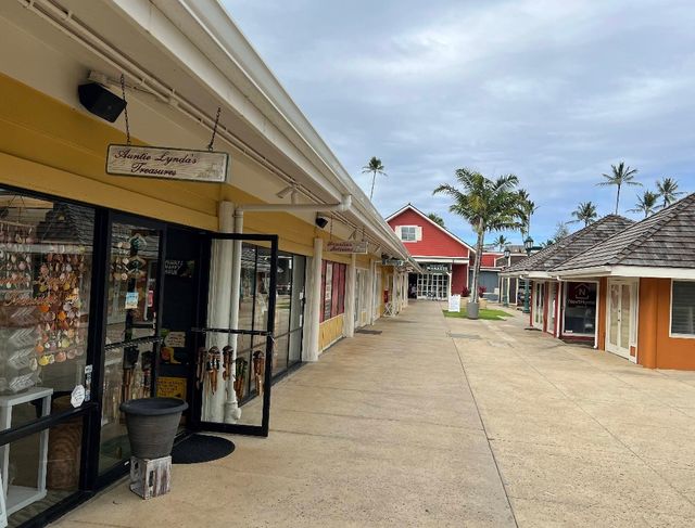 Open-air walkway at Coconut Marketplace with colorful local shops and palm trees