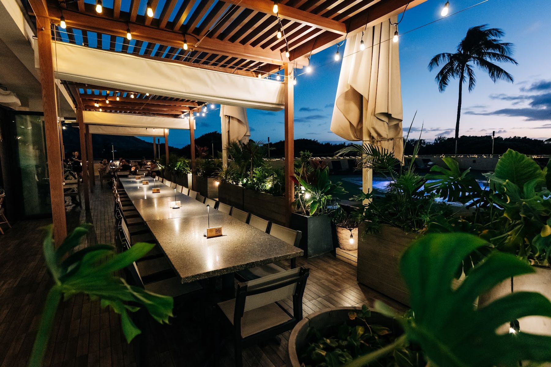 Evening lighting over the covered outdoor dining tables at DECK.