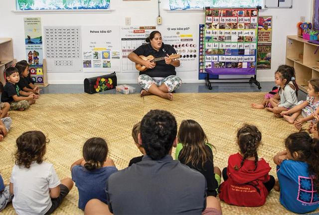 young children in a classroom setting receiving instruction from a woman with a ukelele