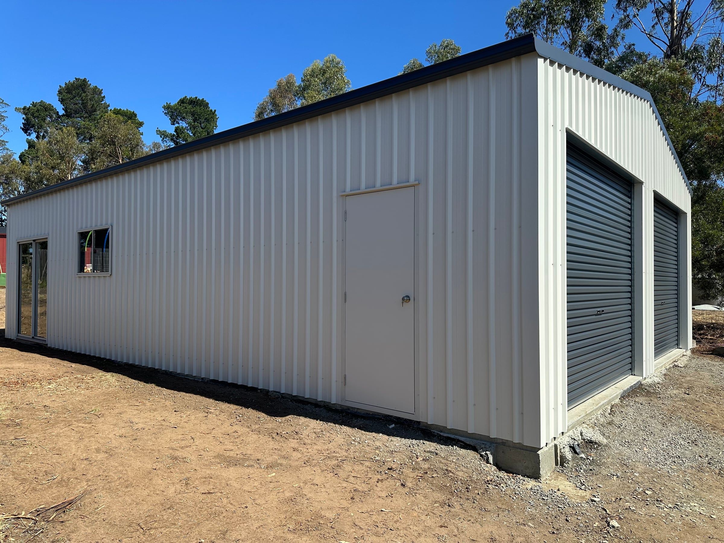 Side of the garage with the Surfmist walk-in door beside the front roller doors