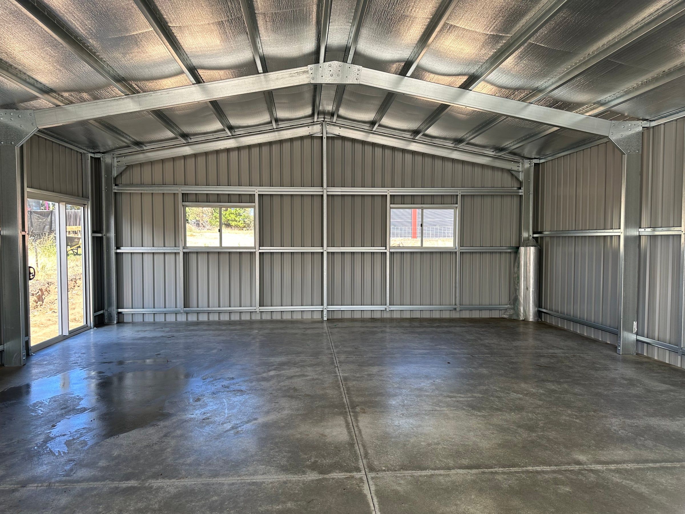 Interior looking toward the rear wall, with two windows and the sliding glass door letting in light