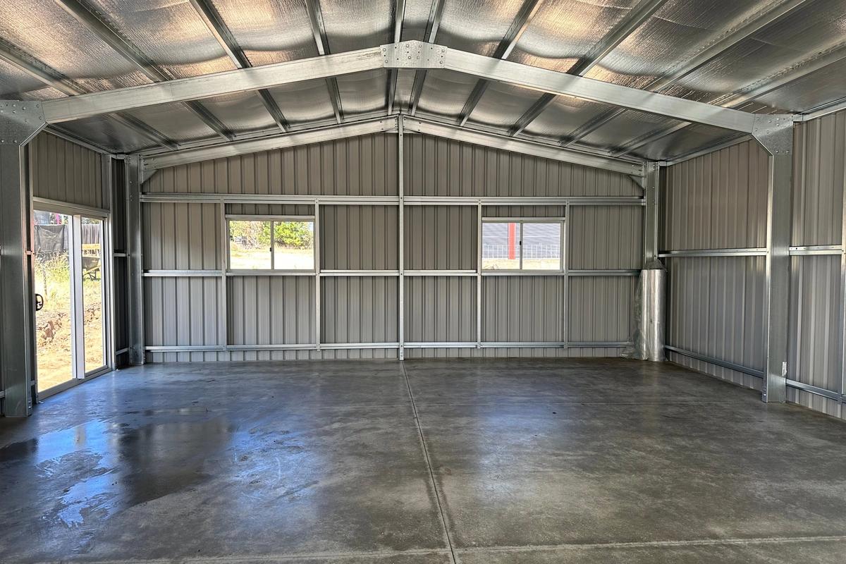 Interior looking toward the rear wall, with two windows and the sliding glass door letting in light