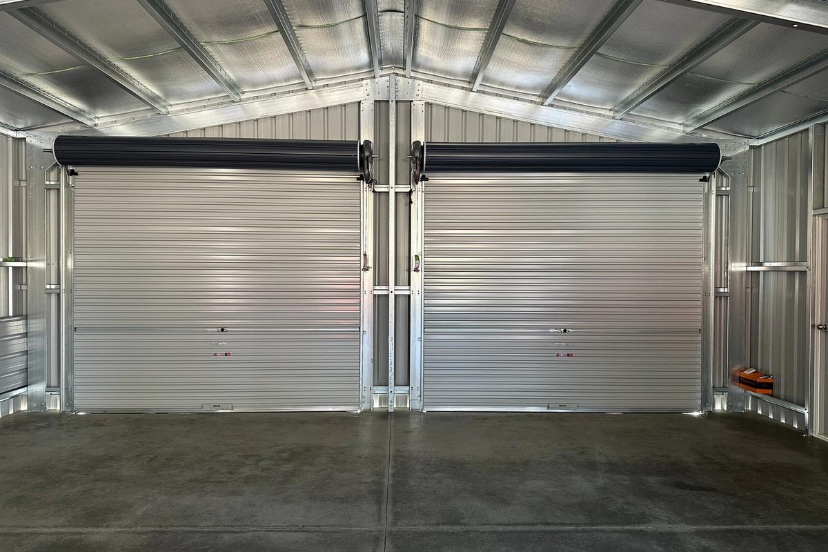 Both roller doors from inside the garage, above a smooth concrete slab