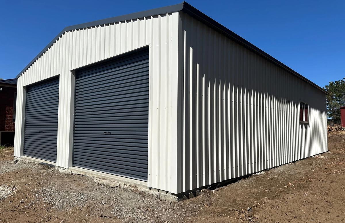 Finished Pontville garage from the front corner, with Ironstone roller doors and Surfmist walls