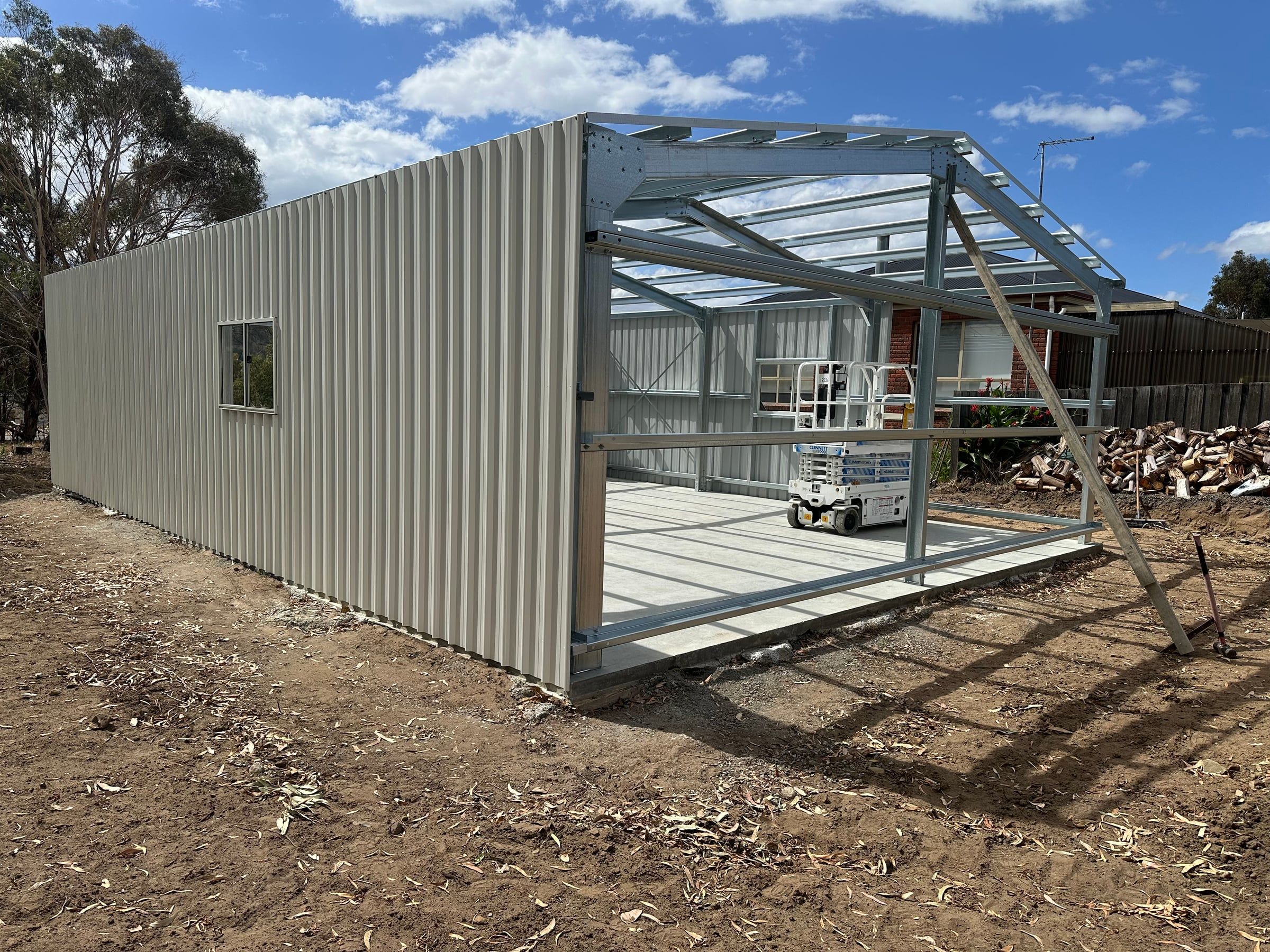 Garage mid-build with the walls clad and the roof framing still open