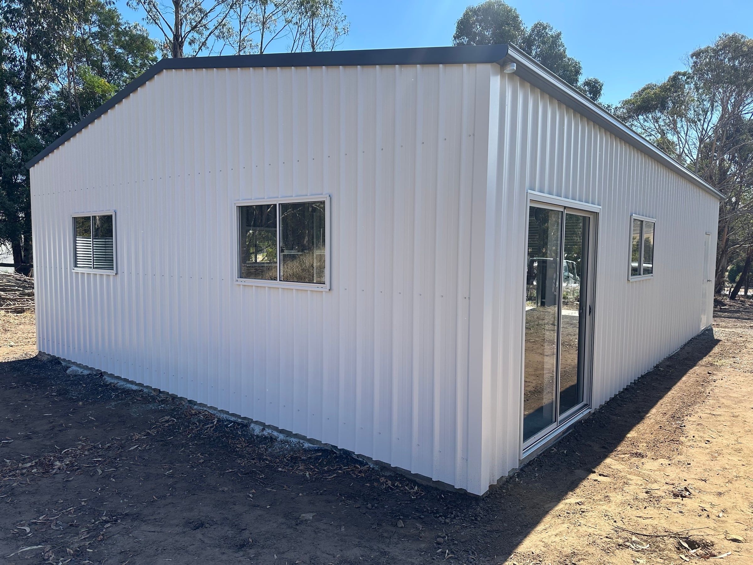 Rear corner of the Surfmist garage showing a sliding window and the sliding glass door