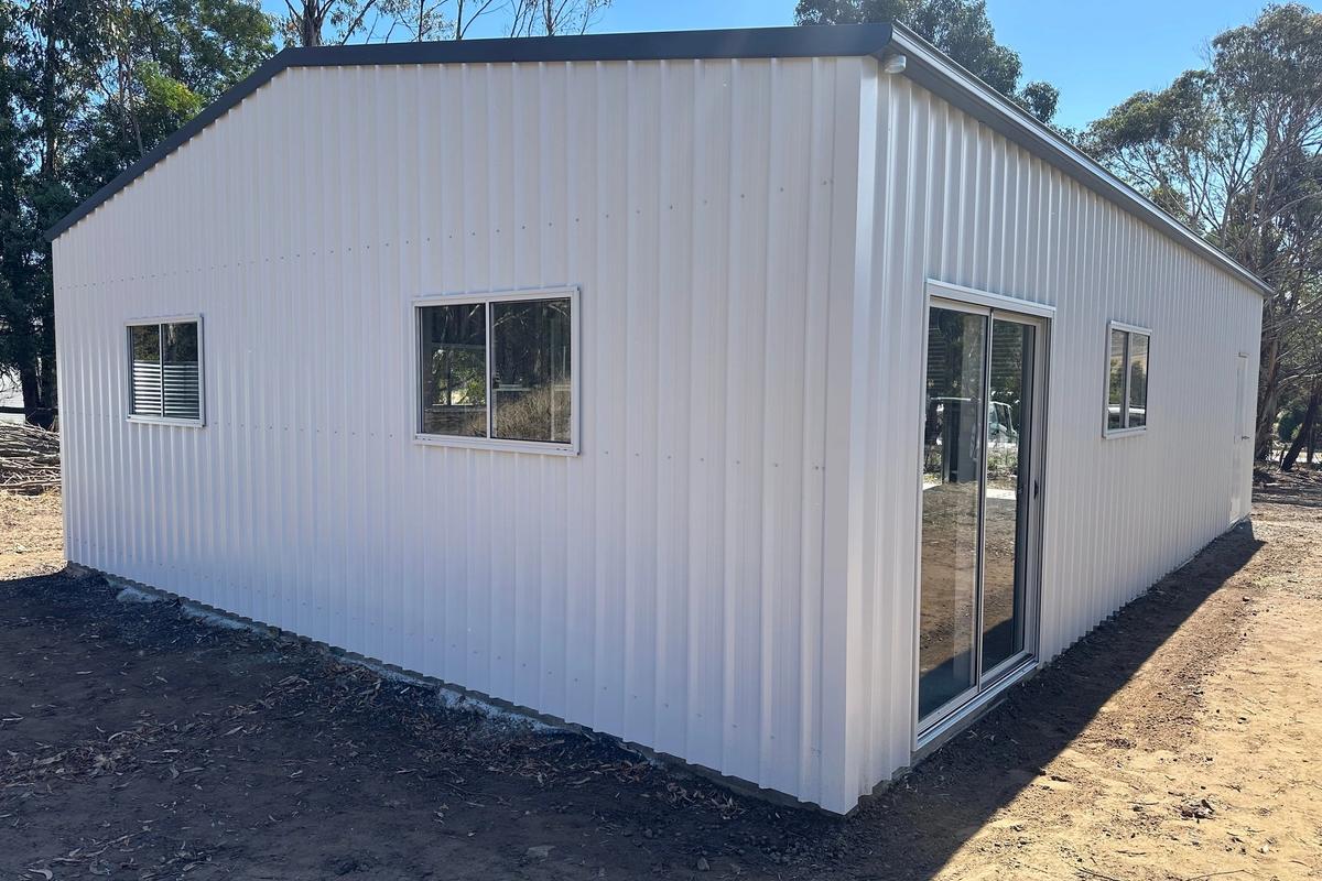Rear corner of the Surfmist garage showing a sliding window and the sliding glass door