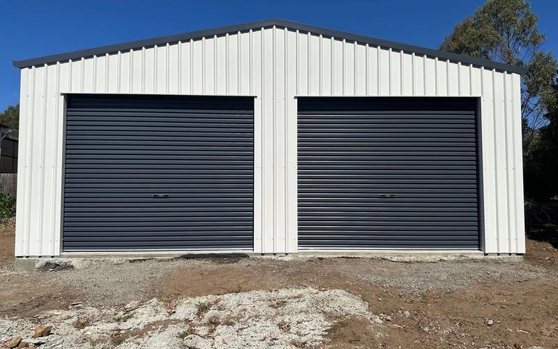 8m x 12m Colorbond garage in Pontville with two Ironstone roller doors and Surfmist walls