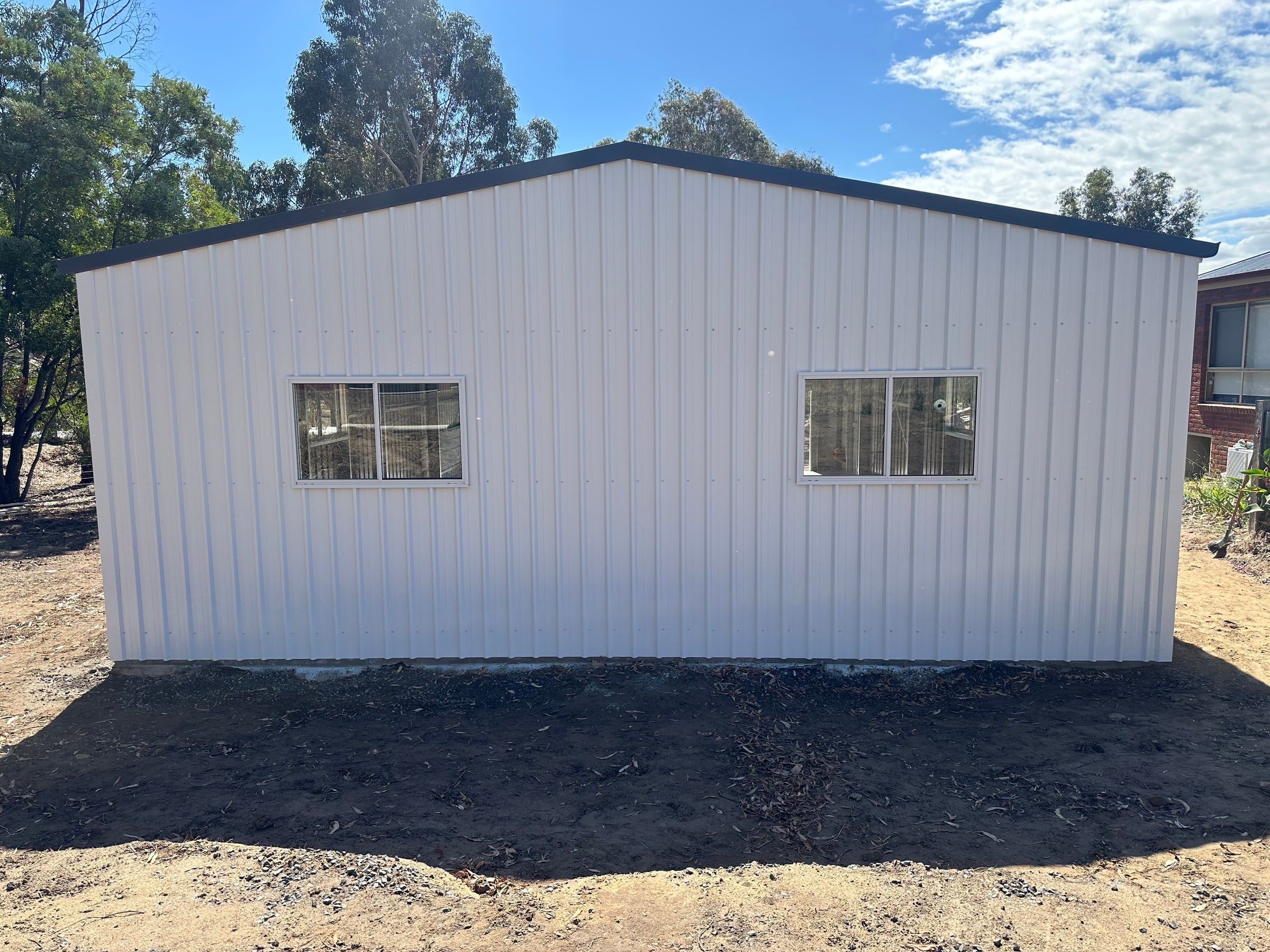 Rear wall of the garage with two sliding windows under the Ironstone roof