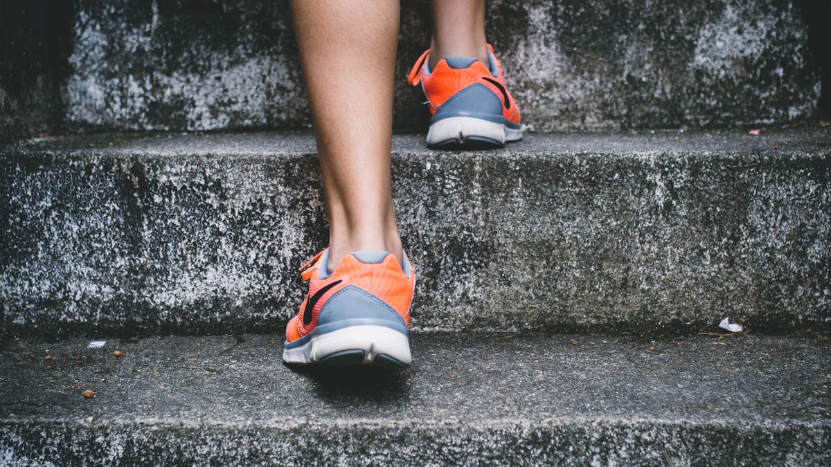 Legs in orange sports shoes walking upstairs