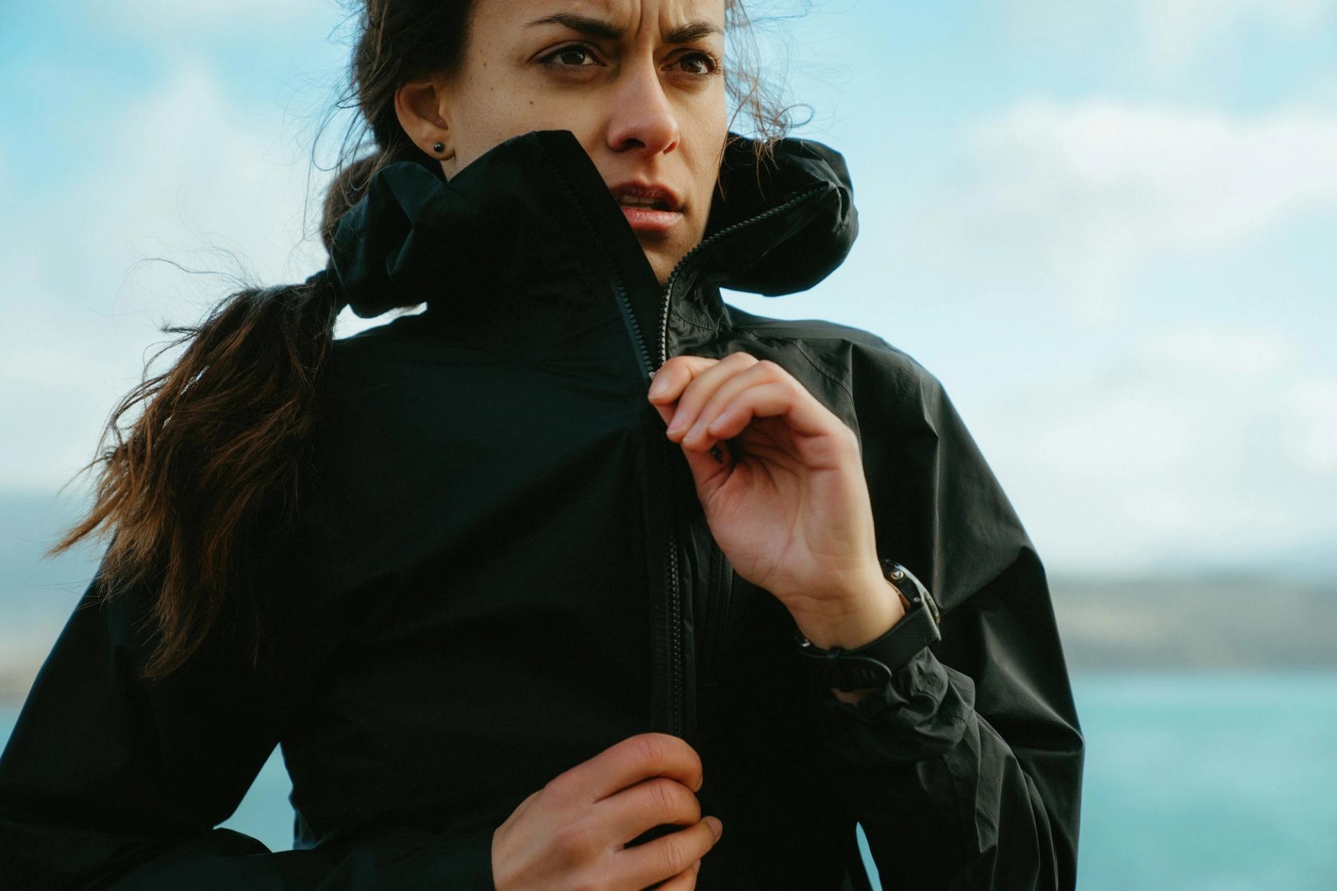 Portrait of a runner zipping up her jacket by the coast — Björn Lexius, Iceland