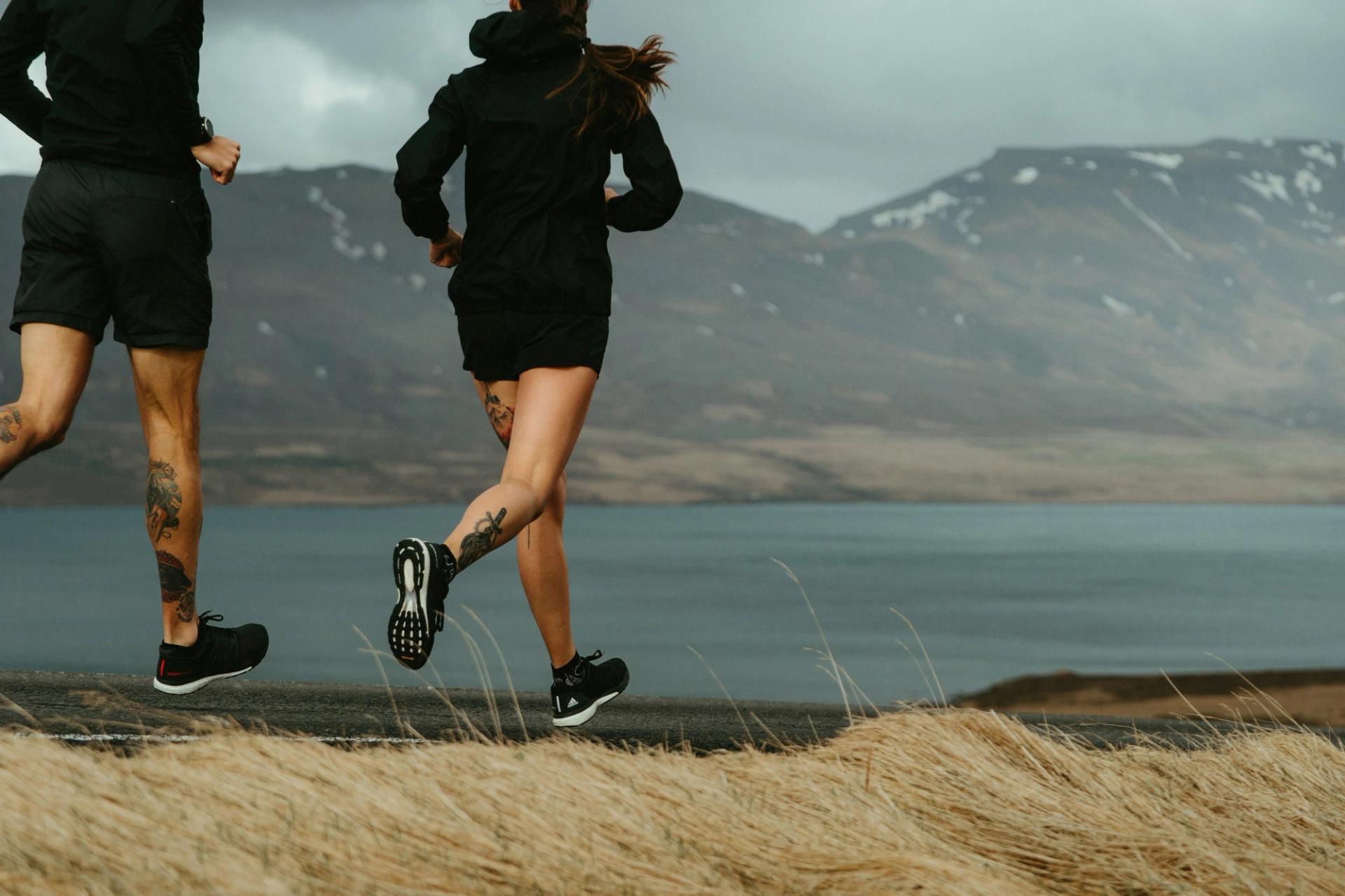 Close-up of two runners' legs beside a lake — Björn Lexius, Iceland