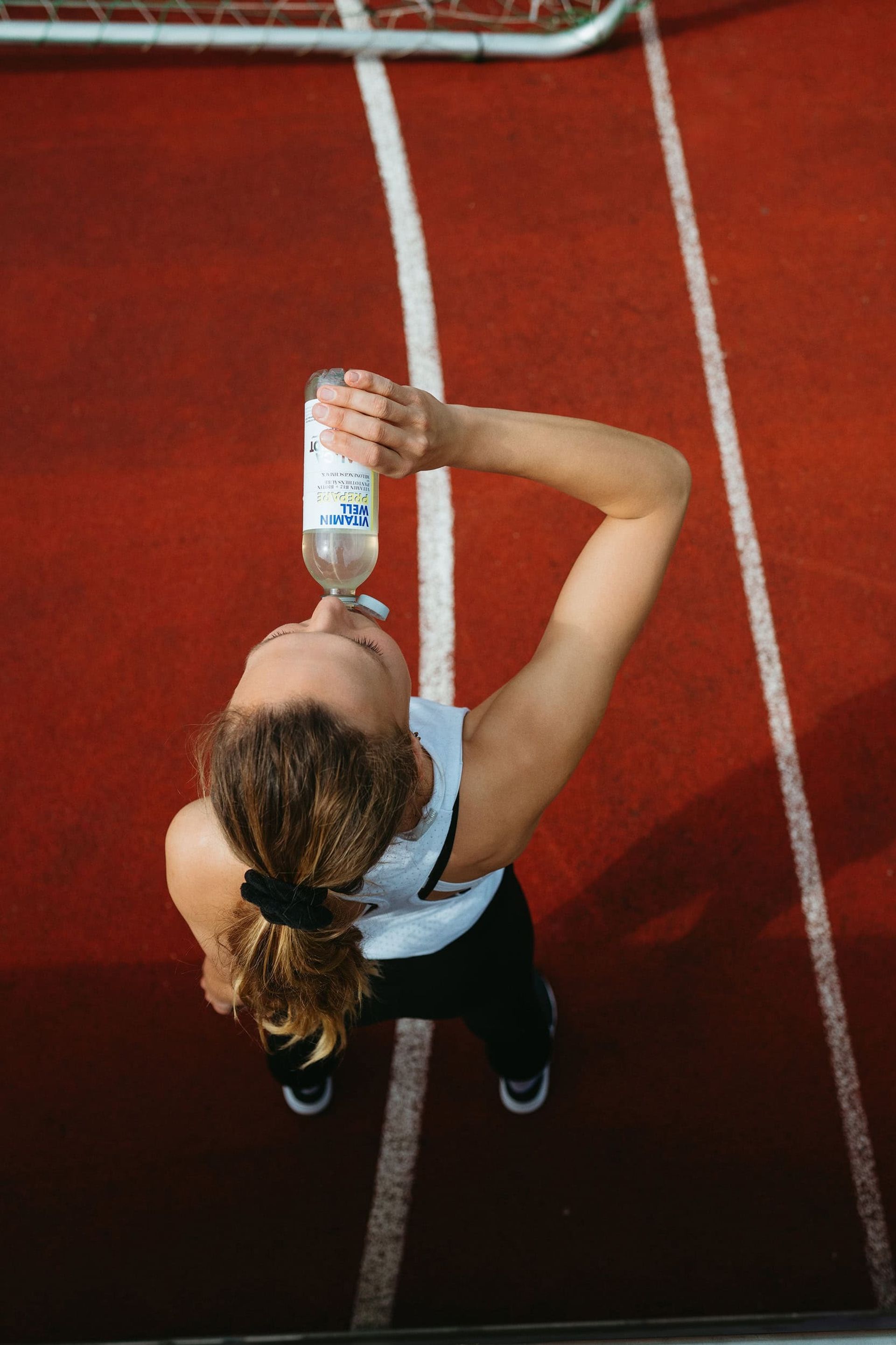 Overhead shot of athlete drinking from Prepare bottle on track — Björn Lexius, Hamburg