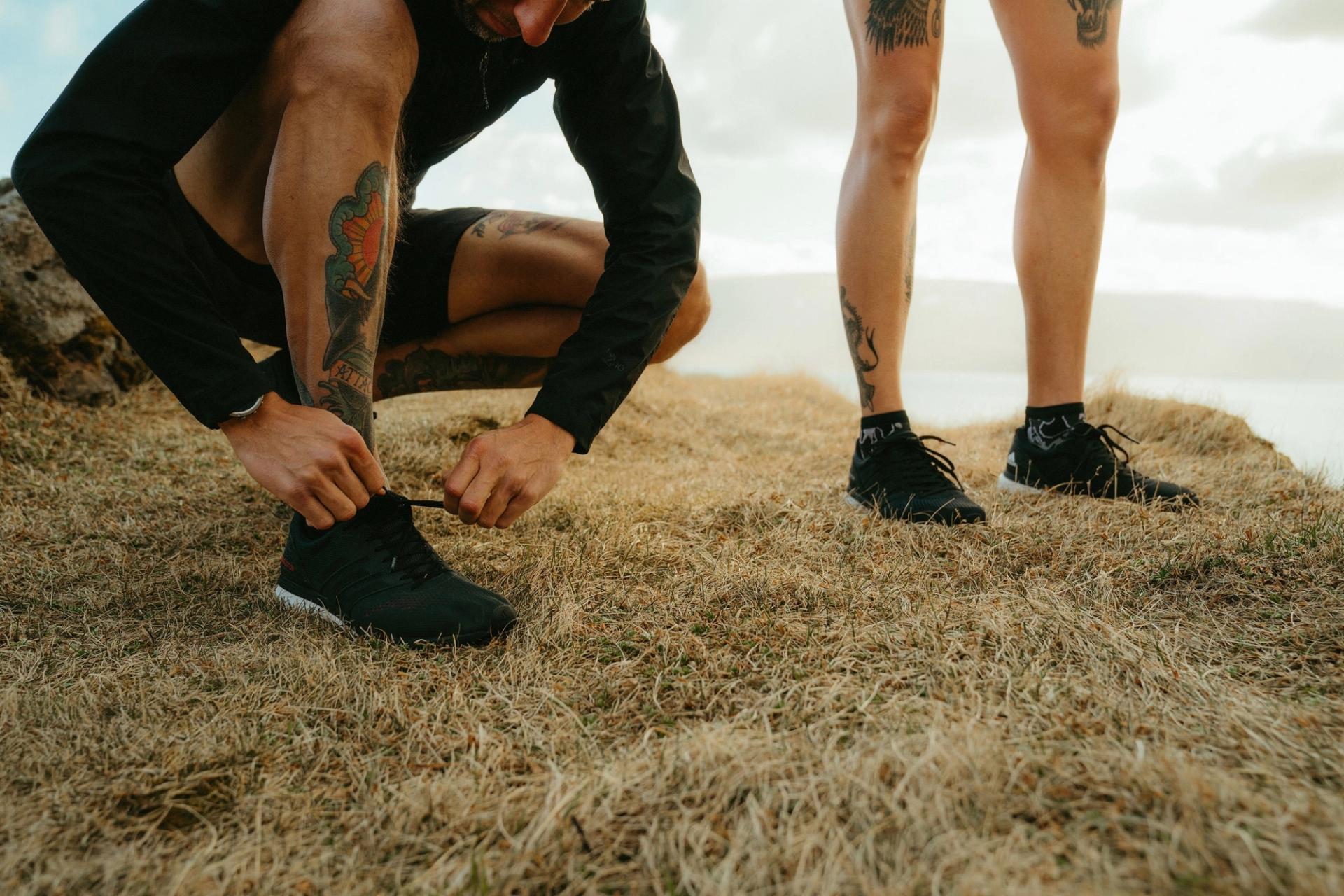 Runner tying his shoe on a coastal cliff — Björn Lexius, Iceland