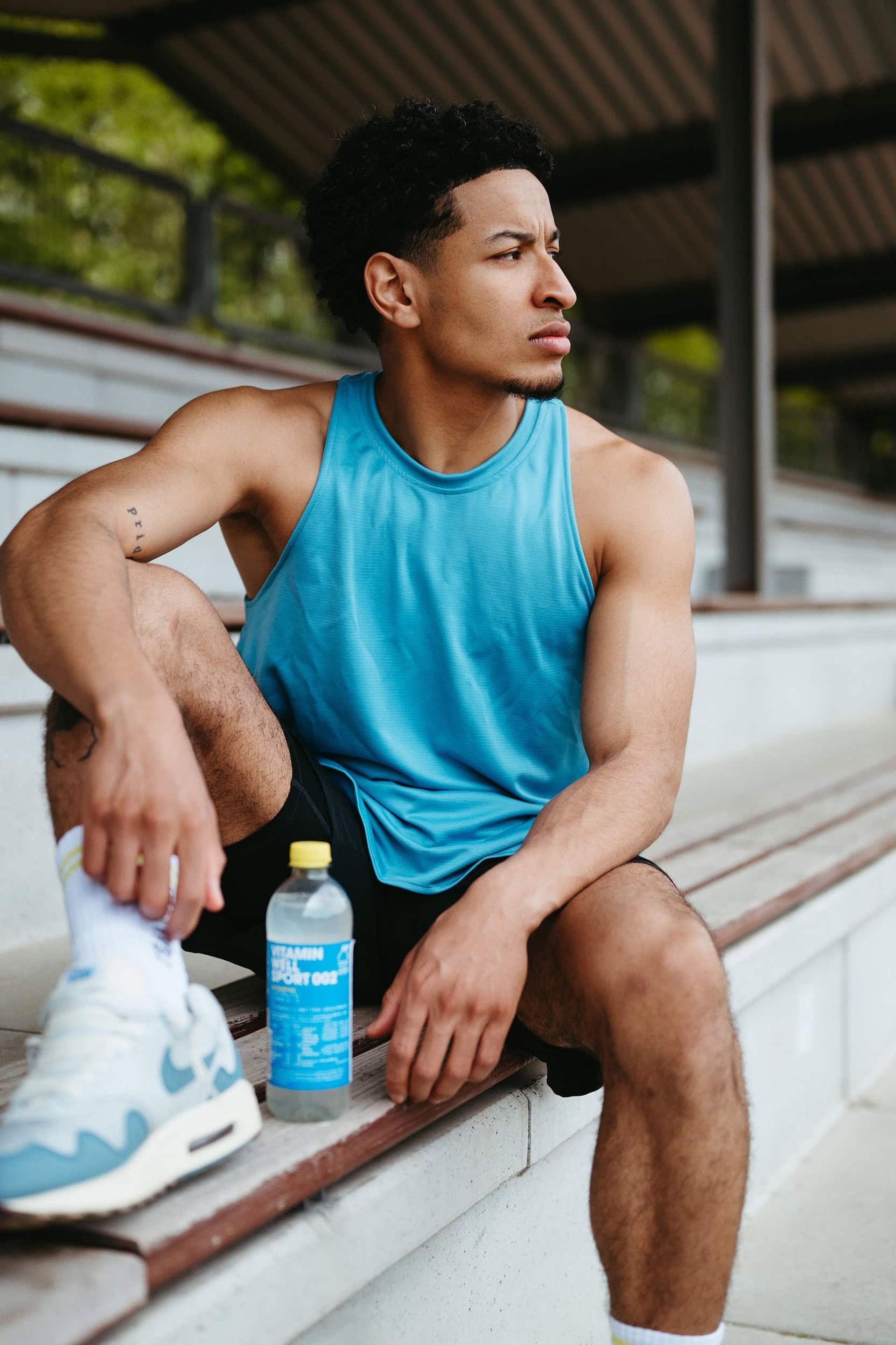 Athlete in teal tank top holding Sport 002 bottle — Björn Lexius, Hamburg