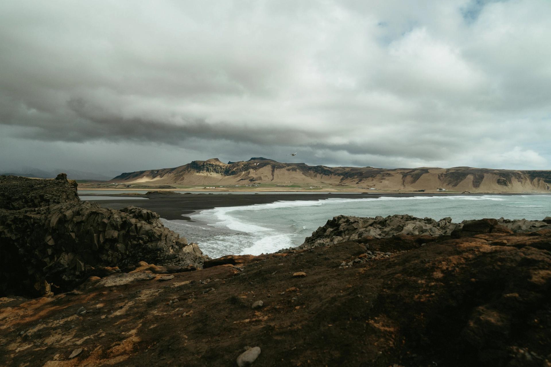 Black sand beach and waves under a stormy sky — Björn Lexius, Iceland