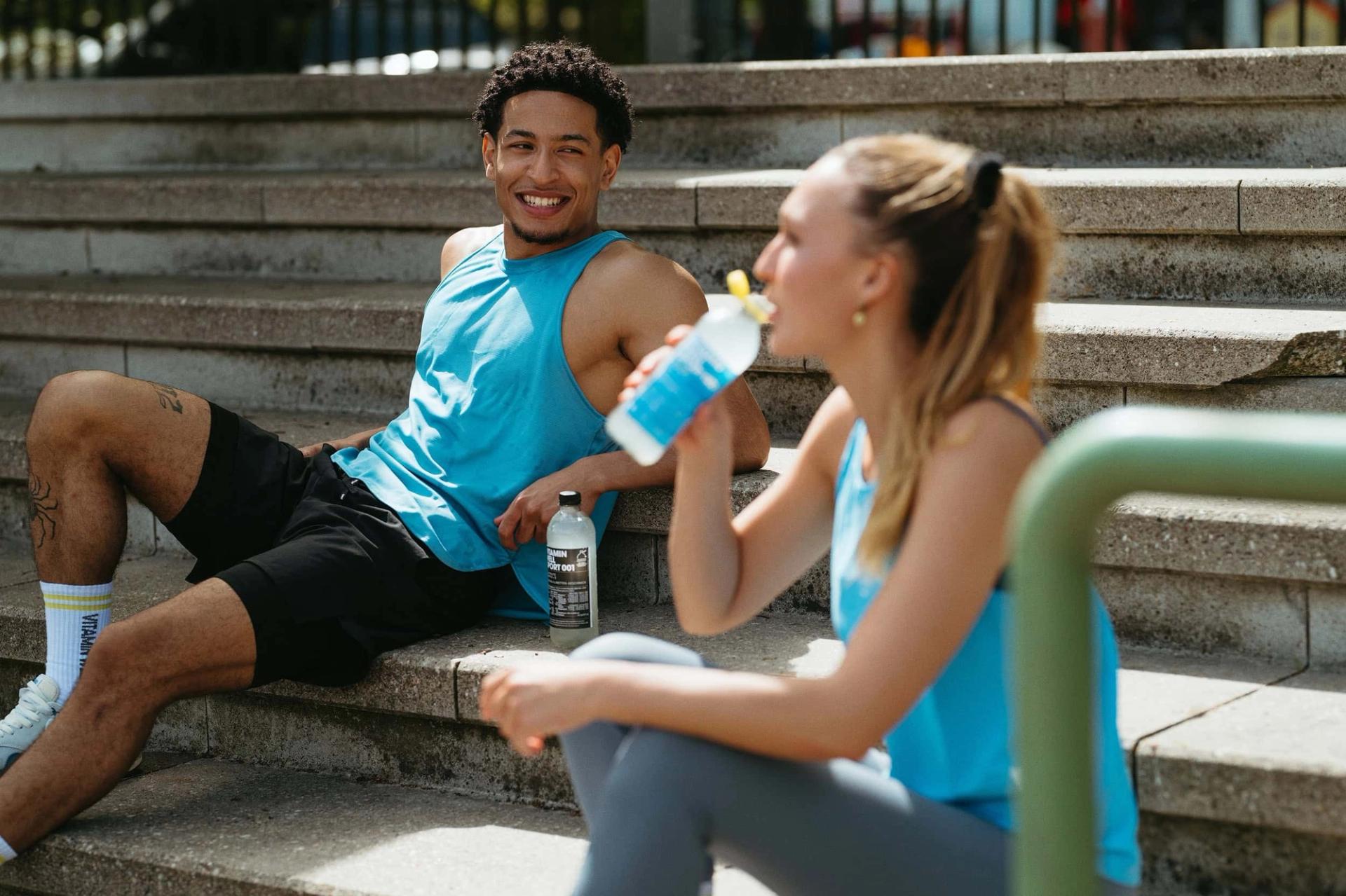 Two athletes on steps, one drinking from Sport 001 with a straw — Björn Lexius, Hamburg