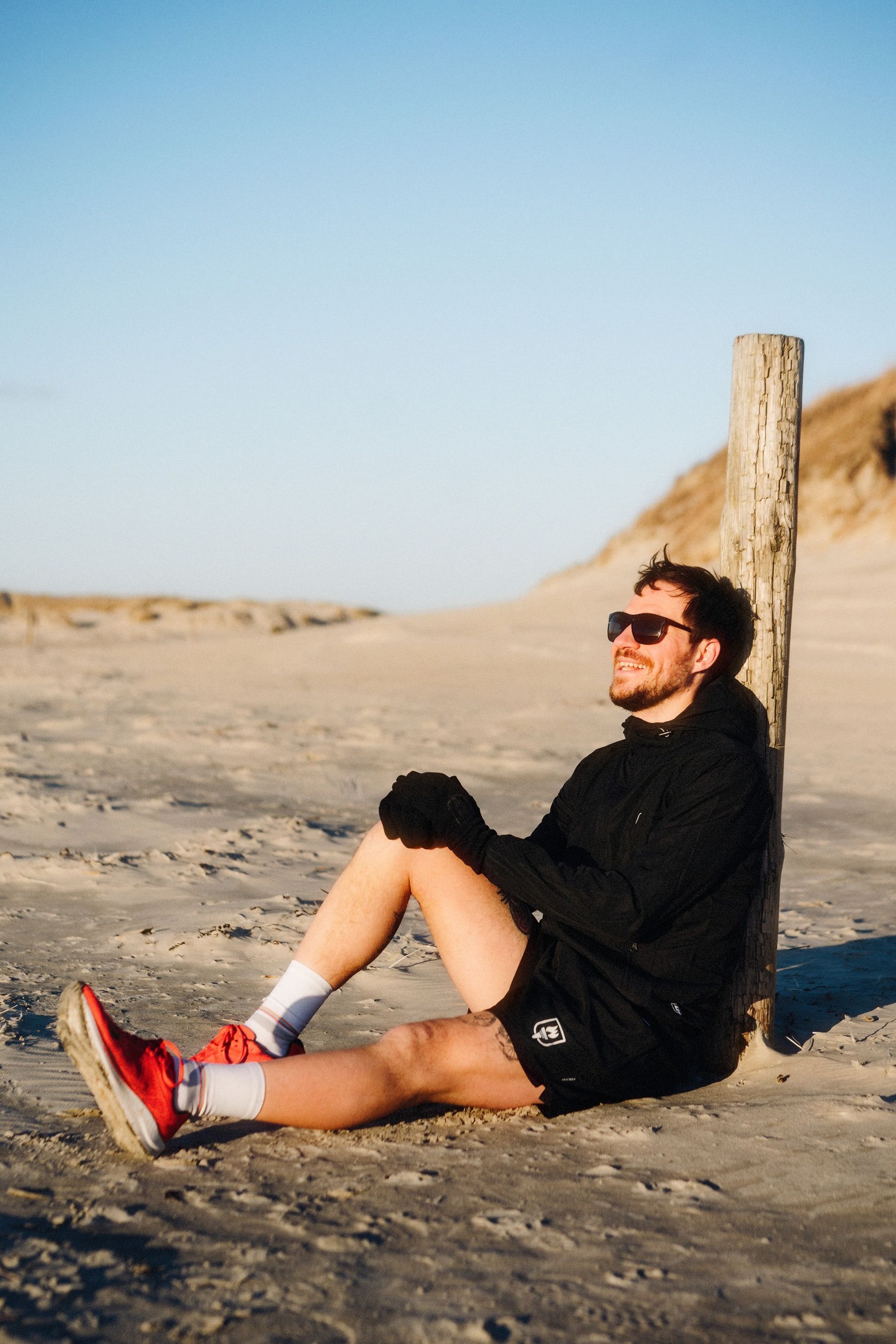 Runner seated beach post — Björn Lexius, Sankt Peter-Ording