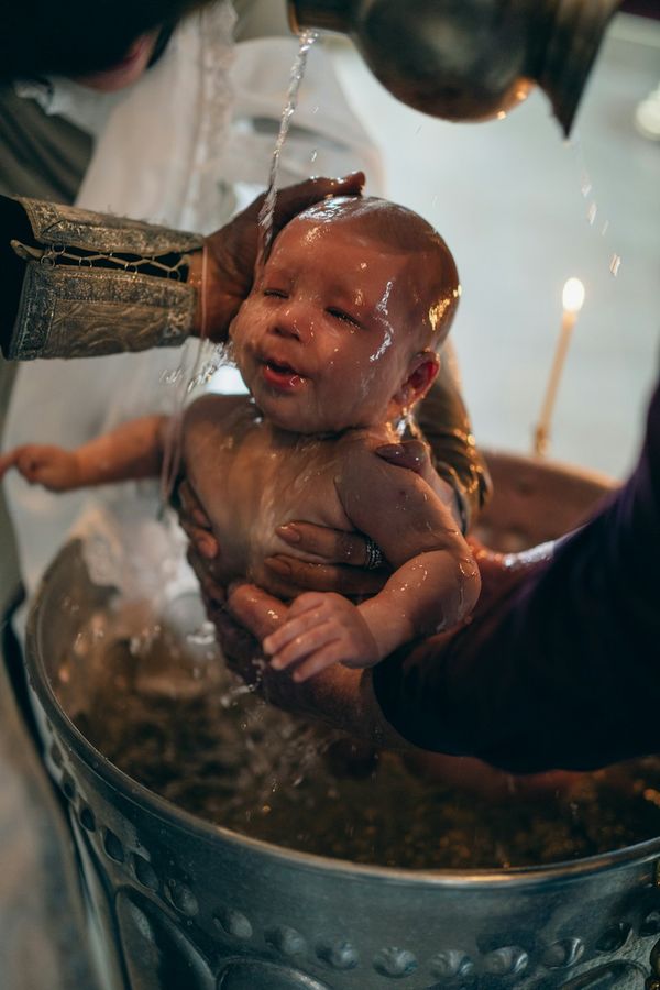 Bambino tra le braccia della madre durante il rito