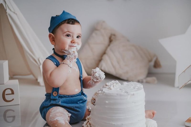 Bambino con la torta durante uno smash cake