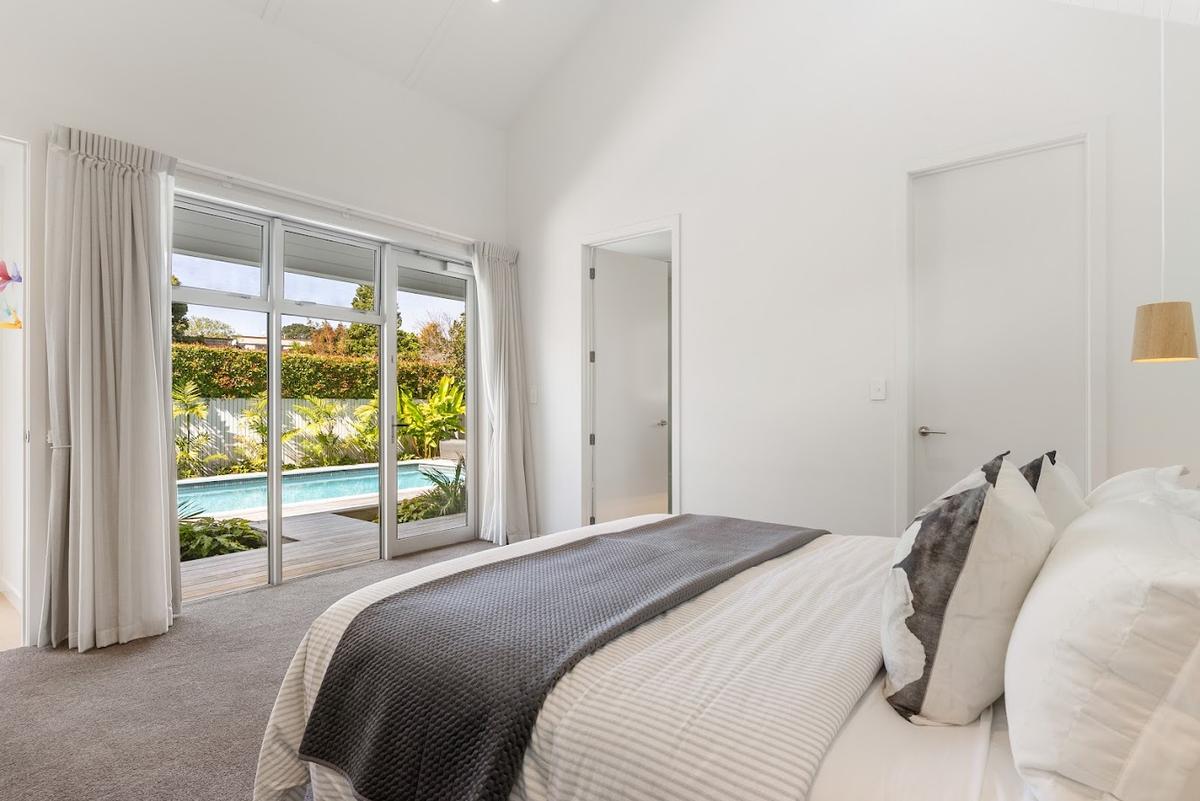 Bedroom with sliding doors to the pool and a raked ceiling