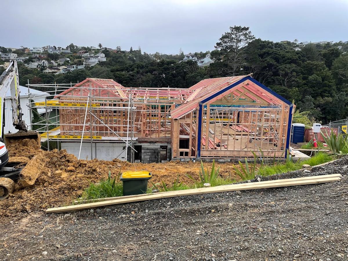 Roof framing across both gables, with the harbour beyond