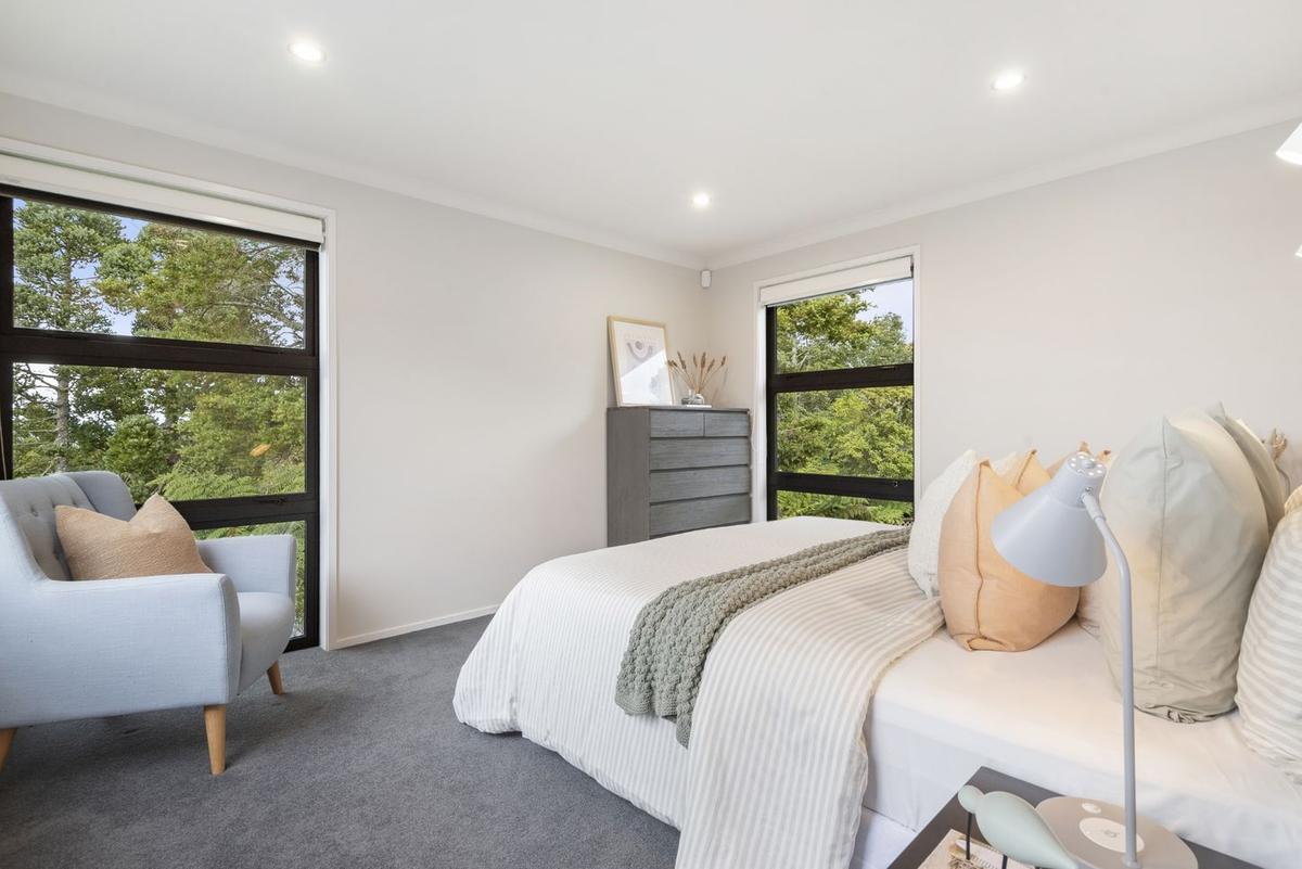 Bedroom with windows framing the surrounding bush