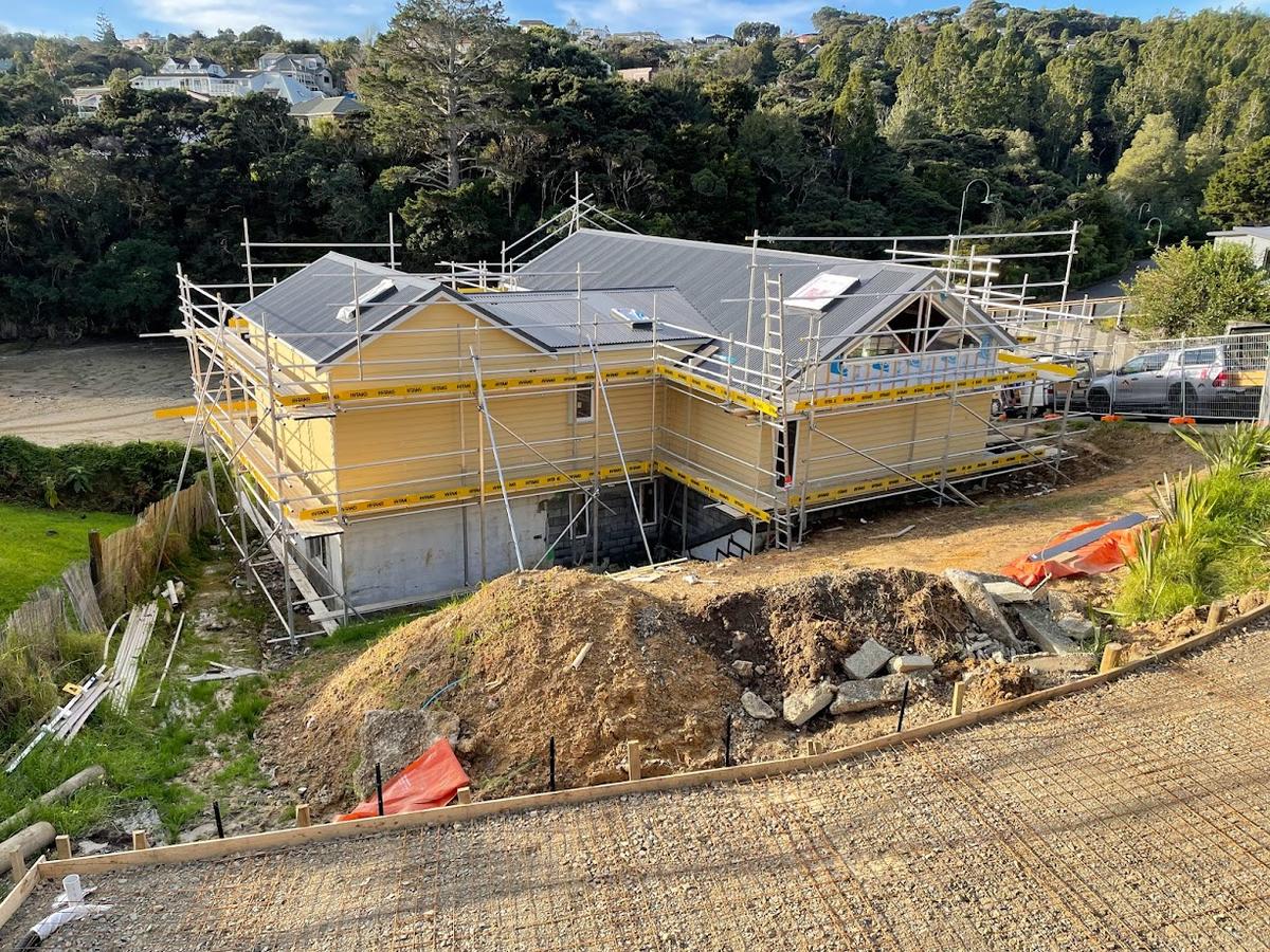 Aerial view of the wrapped and scaffolded house on its sloping site