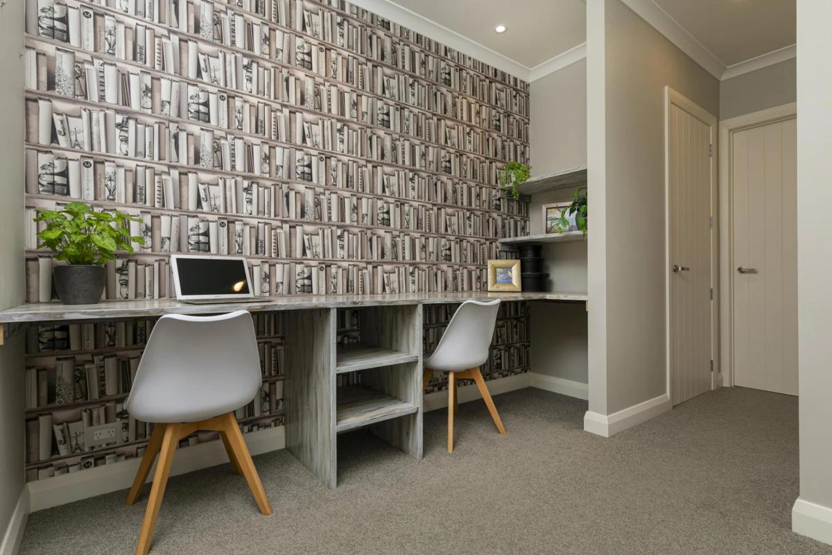 Built in study with two desks against a patterned feature wall