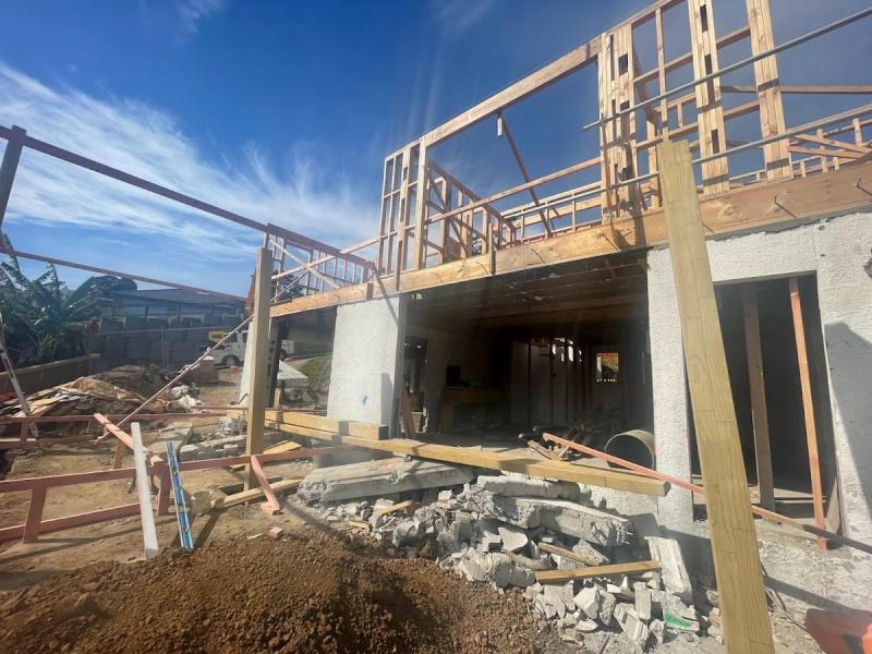 Timber framing rising above the new concrete block lower level