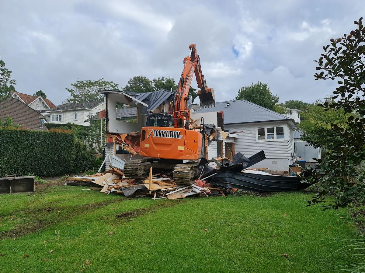 Excavator demolishing the original rear of the house