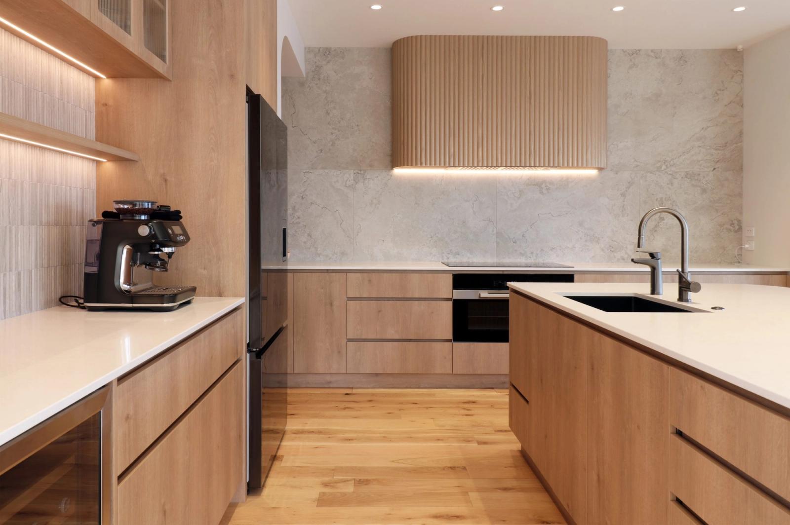 Renovated kitchen in oak with a marble splashback and fluted range hood