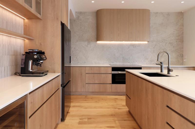 Renovated kitchen in oak with a marble splashback and fluted range hood