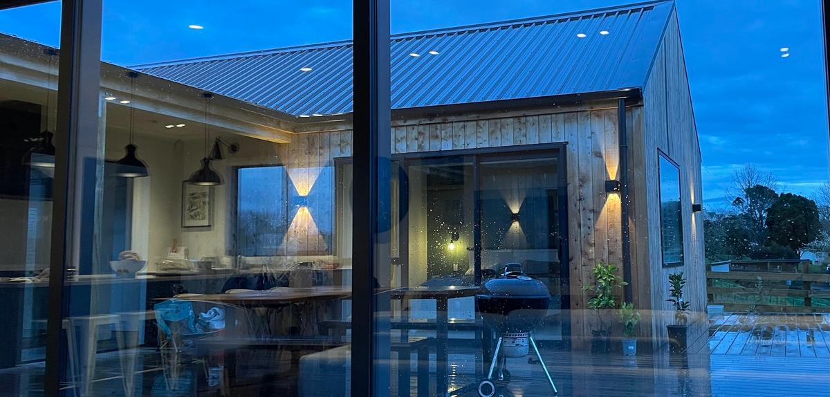 Looking through the glazing to the covered deck at dusk